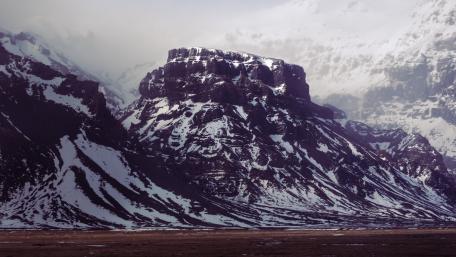 Majestic Snow-Capped Mountains Standing Tall Amongst the Clouds wallpaper