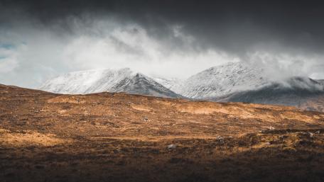 Majestic Highland Mountains Under Cloudy Skies wallpaper