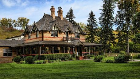 Charming Victorian Home Surrounded by Lush Greens wallpaper