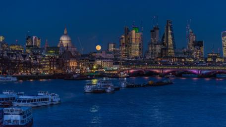 Cityscape at Night with Full Moon and River View wallpaper