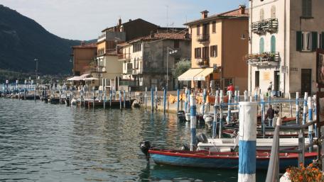 Charming Lakeside Village with Colorful Boats and Quaint Architecture wallpaper