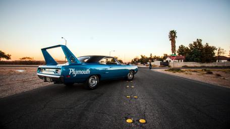 Classic Plymouth Muscle Car on Open Road at Sunset wallpaper