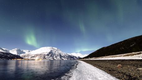 Majestic Aurora Borealis Over Snowy Landscape wallpaper