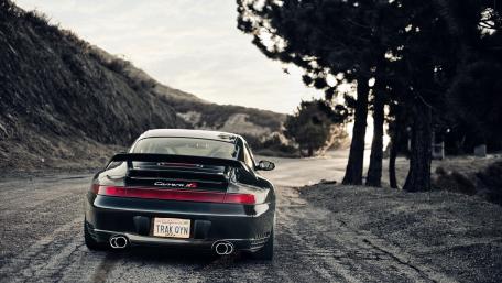 Rear View of a Porsche Carrera on Scenic Road wallpaper