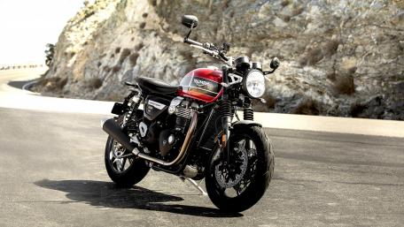 Stylish Triumph Motorcycle on a Scenic Road wallpaper