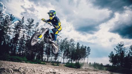 Rider in Mid-Air Over Rugged Terrain wallpaper