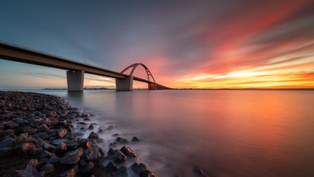 Vibrant Sunset Over the Bridge and Shoreline wallpaper