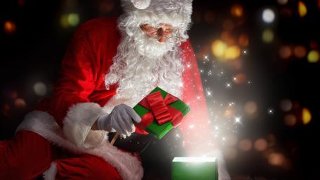 Joyful Santa Unveils Magic Gifts Under Christmas Lights wallpaper