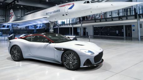 Sleek Aston Martin Under Iconic Concorde Aircraft wallpaper
