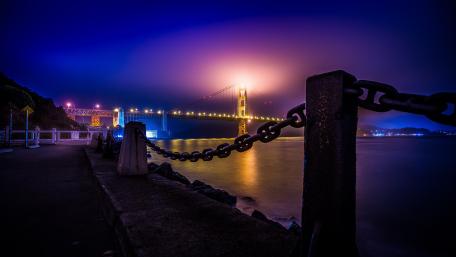 Bridge Illuminated by Dusk Glow Over River Scene wallpaper