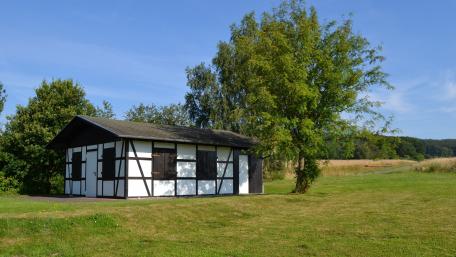 Serene Cottage in a Lush Green Field wallpaper