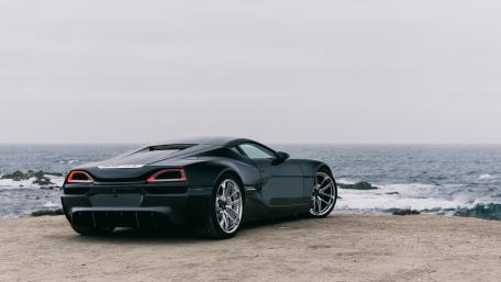 Sleek Black Dream Car by the Ocean wallpaper