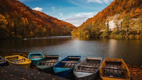 Tranquil Autumn Lake with Colorful Boats wallpaper
