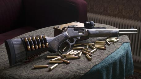 Vintage Rifle Display in Rustic Setting wallpaper