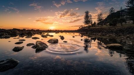 Tranquil Sunset Over a Serene Riverbed wallpaper