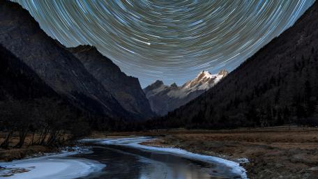 Mystical Star Trails Over Mountain Valley wallpaper