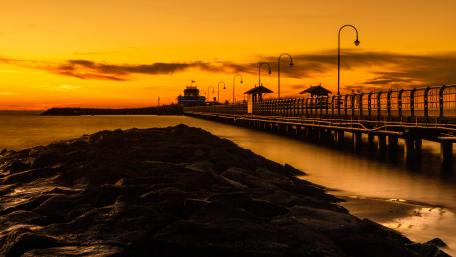 Golden Sunset Over Pier and Bridge wallpaper