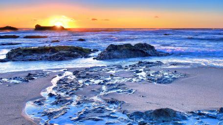 Serene Beach Sunset over Ocean Waves wallpaper