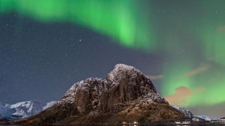 Majestic Aurora Dancing Over Snowy Peaks wallpaper