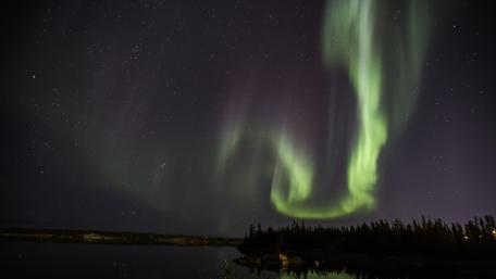 Enchanting Aurora Borealis Over Calm Waters wallpaper