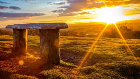Serene Bench at Sunset Overlooking Fields wallpaper