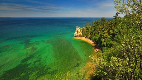 Serene Shoreline Overlooking Blue Waters wallpaper