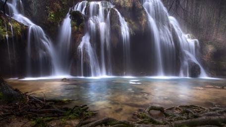 Serene Waterfall in a Tranquil Forest Scene wallpaper