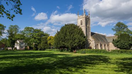 Stunning Church Surrounded by Lush Greenery and Blue Skies wallpaper