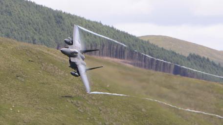 Fighter Jet Soaring Over Mountains wallpaper