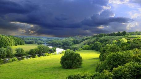 Majestic River Valley Under Cloudy Sky wallpaper