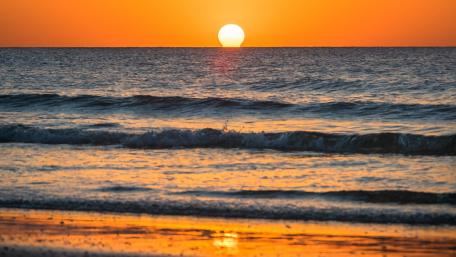 Golden Sunset Over Tranquil Ocean Waves wallpaper