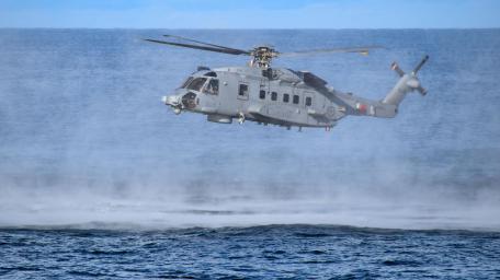 Sleek Military Helicopter in Action Above the Ocean wallpaper