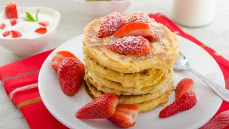 Delicious Pancakes Topped with Fresh Strawberries and Creamy Delightful Flavors wallpaper