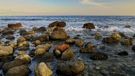 Serene Beach Stones Under a Clear Horizon wallpaper