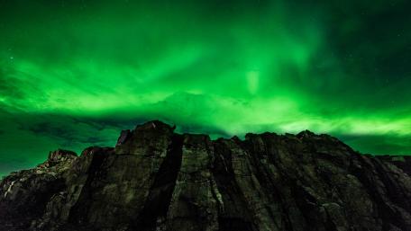 Emerald Lights Over Mountain Peaks wallpaper