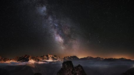 Celestial Majesty Over Mountain Peaks wallpaper