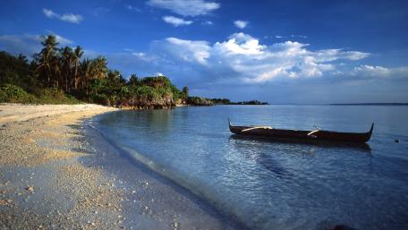 Serene Beach with Tranquil Waters and Boat View wallpaper