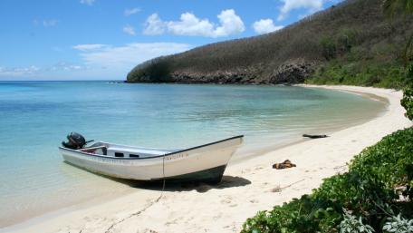Serene Beachside Escape with a Motorboat wallpaper