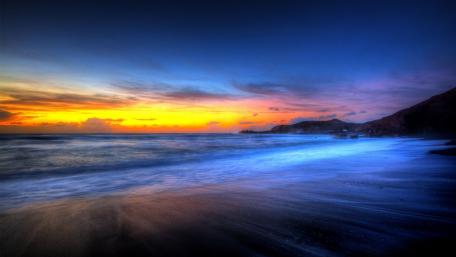 Vibrant Sunset Over Serene Beach Waters wallpaper