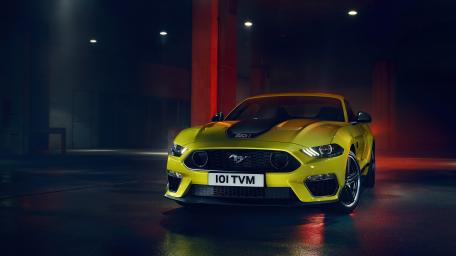 Sleek Yellow Ford Mustang Under City Lights wallpaper