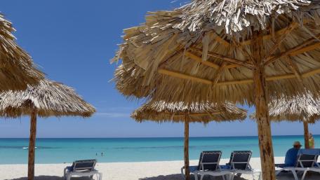 Tropical Beach Escape with Palapas and Sunbeds wallpaper