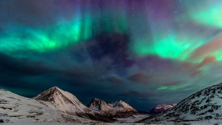 Majestic Northern Lights Dance Above Snowy Peaks wallpaper