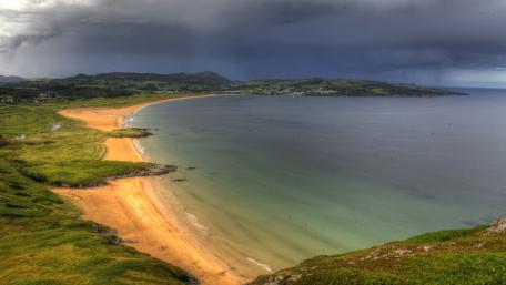 Serene Coastal View Beneath Dramatic Skies wallpaper
