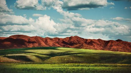 Vibrant Landscape with Rolling Hills and Clouds wallpaper