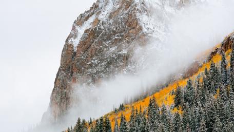 Majestic Autumn Mist Over Rocky Cliffs wallpaper