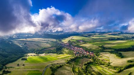 Breathtaking Aerial View of Serene Landscape Spanning Green Fields and Hills wallpaper