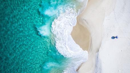 Tranquil Blue Waves Meet Sandy Shores wallpaper