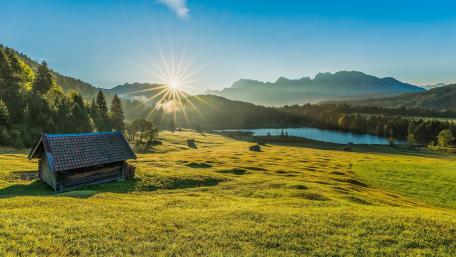 Serene Cottage Amidst Sunlit Nature Landscape wallpaper