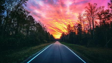 Vibrant Sunset Over Serene Roadway wallpaper