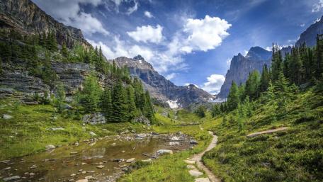 Serene Valley Amidst Majestic Mountains wallpaper